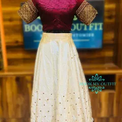 This elegant lehenga set features a cream-colored skirt with subtle gold motifs and a rich maroon brocade blouse. It's a sophisticated choice for a reception or engagement party.