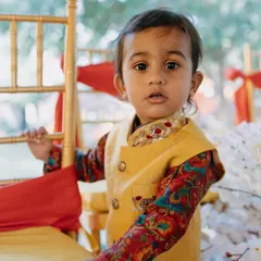 Another sweet shot from the Haldi ceremony. This little one looks absolutely charming in his custom-designed yellow Bundi and colorful printed kurta.