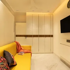 This guest bedroom is a masterclass in multi-functionality. The room features a comfortable sofa, a full-sized wardrobe, and a wall-mounted bed that is hidden from view during the day.