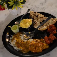 A plate filled with our delicious buffet lunch, including rice, curry, naan, and starters. We ensure there's something for every palate.