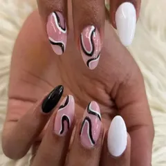 A high-contrast abstract design, combining a sheer pink base with black swirls, and solid black and white accent nails.