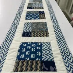 A beautiful table runner made with traditional indigo block-printed fabrics. The simple patchwork design is elegant and timeless.