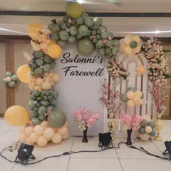 For this farewell party, I created a stylish photo booth using a custom backdrop and an organic balloon arch in trendy sage green and peach tones. This setup combines fresh flowers with modern balloon artistry for a memorable celebration.