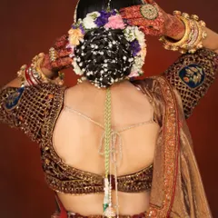 A closer look at a traditional bridal bun. You will learn how to securely place floral and jeweled accessories to create a balanced and beautiful hairstyle that complements the bride's entire look.