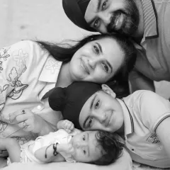 A perfect family portrait. This black and white photo captures four smiling faces, showing the love and connection within this beautiful family.