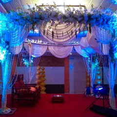 The same mandap structure can be transformed with lighting. Here, blue lights give the white drapes and floral arrangements a dramatic and modern feel for an evening wedding.
