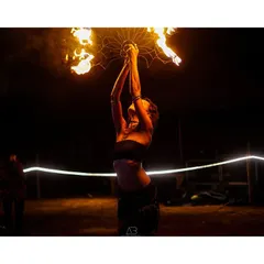 A powerful moment of a fire performer, holding the flames aloft. This shot captures the strength and focus required for such a performance.