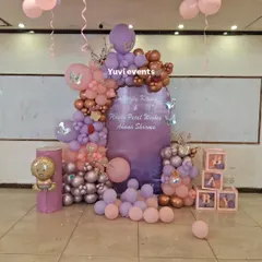 A beautiful balloon setup in shades of purple, pink, and rose gold, with butterfly accents and "BABY" blocks.