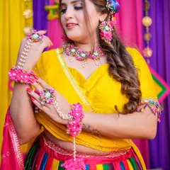 A vibrant Mehendi look! The bride is glowing in her colorful rainbow lehenga and floral jewelry, with makeup that is fresh and fun.