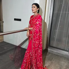 A classic red saree paired with an elegant, clean bun. This timeless hairstyle is perfect for showcasing statement jewelry and a beautiful blouse neckline.