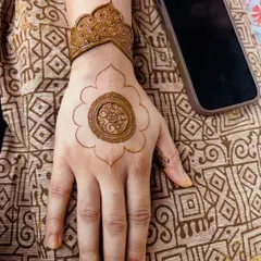 The start of the mandala design, showing the clean outlines of the central motif and wrist cuff.