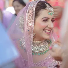 A close-up of a bride's joyful, candid smile. This shot captures the genuine happiness and excitement of the wedding day, framed by the crowd of loved ones.