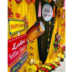 A detailed shot of the Lohri selfie station, highlighting the "Lohri Selfie Station" sign and the dhol cutout, adding a fun, interactive element to the party.