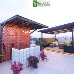 A wide view of the Palam Vihar rooftop, showing the custom bar with its unique tile front and the separate pergola seating area.