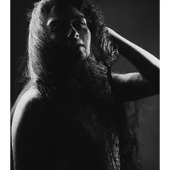 A different crop of the same artistic portrait, this time in a vertical format. The black and white conversion emphasizes the texture and the play of light and shadow.