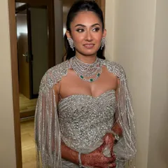 A full-length view of this breathtaking silver gown. The makeup is glamorous and sophisticated, designed to match the high-fashion feel of the outfit.
