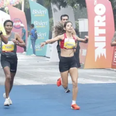 Crossing the finish line at the Vedanta Delhi Half Marathon to secure first place in my age category. This victory was a comeback story, healing from physical and emotional setbacks.