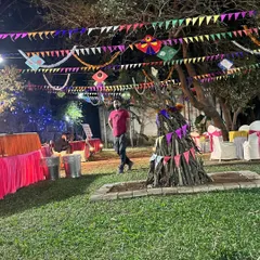 Another view of the festive Lohri party setup, showing the decorated trees and seating arrangements around the central bonfire.