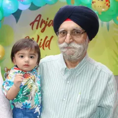 A grandfather from the Sikh community holds his young grandson at a family event. Capturing moments between generations is a key part of our service.