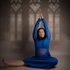 A peaceful and meditative yoga pose. The mother-to-be sits with her hands raised in a prayer position, her calm expression reflecting the inner peace that yoga can bring during pregnancy.