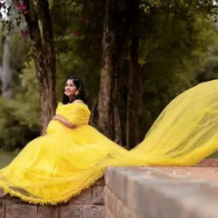 Brighten up your maternity shoot with this cheerful yellow off-shoulder netted tail gown. The long, flowing tail adds a touch of drama and playfulness to your photos, perfect for an outdoor setting.