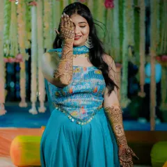 A playful bride covers one eye with her mehndi adorned hand, a fun and charming portrait from her Mehndi ceremony.