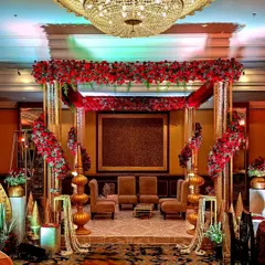 For this royal-themed wedding, I designed a grand mandap with ornate golden pillars, a canopy of red roses, and cascading floral strings, creating a truly regal setting.