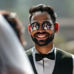 I'm always looking for creative ways to tell your story. Here, the bride's reflection in the groom's sunglasses becomes a multi-layered portrait, a small detail that speaks volumes about their connection. It’s these little creative touches that make your photos unique.