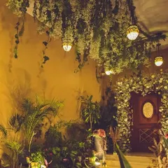 We created a lush, indoor garden feel for this event entrance. A ceiling installation of hanging baby's breath and ivy leads guests toward a beautifully decorated doorway, setting a tone of rustic elegance.