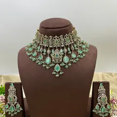 A heavy bridal choker set in a stunning emerald green. This design features multiple layers of stones and bead droppings, complete with matching oversized earrings, making it a comprehensive offering for your bridal customers.