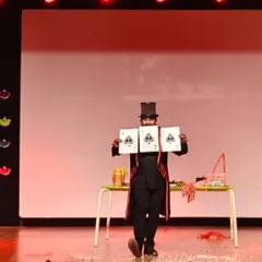 Presenting the giant cards during a stage performance. These oversized props ensure that even guests at the back can see the magic unfold clearly.