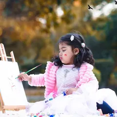 Letting kids be kids makes for the best photos. Here, a little artist is focused on her masterpiece during an outdoor painting-themed session, creating a wonderfully candid moment.