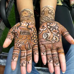 This party-style mehandi features beautiful peacock figures on both palms. The use of negative space makes the peacocks the central focus of the design.