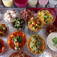 An assortment of vibrant vegetable dishes and pickles from the 56 Bhog spread. You can see preparations like bhindi, mix veg, and palak dal, showcasing a rainbow of flavours.