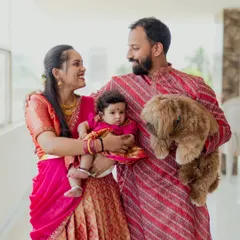 A candid moment during a family portrait session. Natural smiles and interactions between parents, their baby, and their pet are what make these photos so special and authentic.