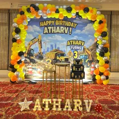 For kids who love big machines, this construction theme is a hit. I designed a full-stage setup for Atharv's 3rd birthday with a vibrant backdrop of diggers and trucks, a yellow, black, and orange balloon arch, and themed cake stands.