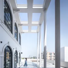 A view of the villa's terrace, where the classical columns create a stunning colonnade. The black and white patterned flooring continues the grand aesthetic of the home's interior.
