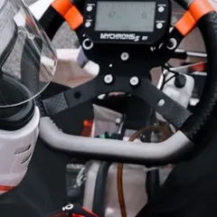The driver's cockpit, featuring a MyChron5 S 2T data logger. This device provides crucial data on lap times, engine temperature, and RPM, which we use for performance analysis.