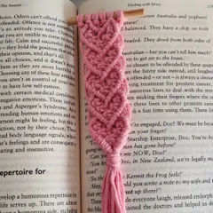 A close-up of the pink heart bookmark resting inside a book. It's a lovely way to hold your place while you read.