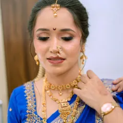 A quiet moment of reflection before the ceremony begins. This shot highlights the soft shimmer on the eyelids and the flawless base that looks like second skin, ensuring the bride is camera-ready from every angle.