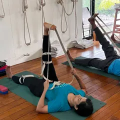 This class is dedicated to 'Nari Shakti', the power of women. Here, students are using belts to work on their leg alignment, a practice that is especially beneficial for hormonal health and stability.