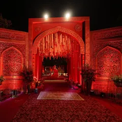 The entrance to a celebration should feel like stepping into another world. I used intricately carved crimson panels and a dramatic arch to create a grand, regal welcome for this wedding.