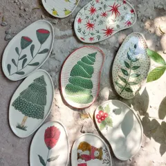 A collection of my hand-painted platters, featuring a variety of festive and floral designs. Each one is a unique piece of functional art, perfect for serving or display.