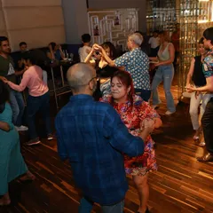 The dance floor is calling. A wide shot of our Havana Nights social, where couples and groups fill the space, learning and enjoying the music together. It's a perfect mix of practice and party.