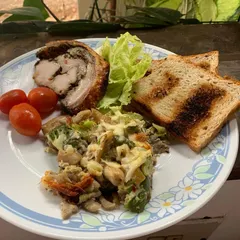 A special Easter plate featuring our Porchetta, which is rolled with a savory liver pâté and fresh herbs. It's served here with toast and a creamy vegetable medley for a complete celebratory meal.