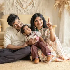 A lovely family portrait including the parents and grandparents. The mother points to something off-camera, creating a natural and engaging scene for everyone.