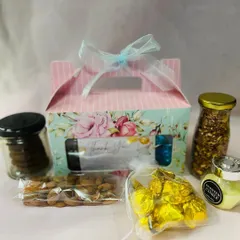 This image shows the contents of one of the baby shower return gift boxes. I included a scented candle, a jar of cookies, almonds, chocolates, and a jar of trail mix.