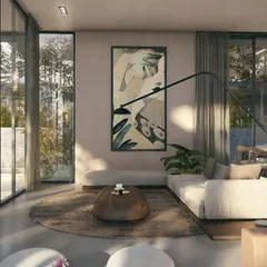 A corner of the living room in a Moira Villa, where soft sunlight filters in. The design uses a neutral palette and natural textures to create a calm, earthy atmosphere that connects to the tropical outdoors.