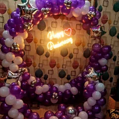 We created this vibrant anniversary backdrop using purple and white balloons, accented with silver star-shaped foils. The "Happy Anniversary" neon sign adds a romantic touch to the celebration.