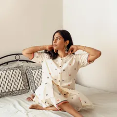 A candid lifestyle image on a bed, capturing a natural moment of the model adjusting her earrings. These shots are effective for social media content as they feel authentic and unposed.